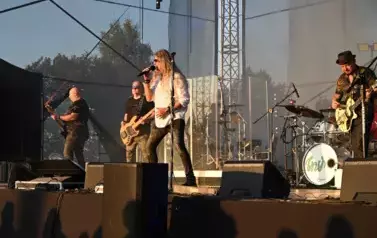 widzimy wokalistę oraz trzech pan&oacute;w grających na gitarze 