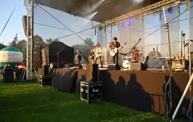 widzimy wokalistę, trzech pan&oacute;w grających na gitarze oraz pana grającego na  perkusji