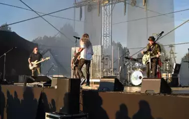 widzimy wokalistę oraz trzech pan&oacute;w grających na gitarze