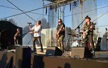 widzimy wokalistę oraz trzech pan&oacute;w grających na gitarze