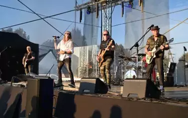 widzimy wokalistę oraz trzech pan&oacute;w grających na gitarze