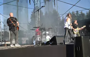widzimy trzech pan&oacute;w grających na gitarze oraz śpiewającego wokalistę