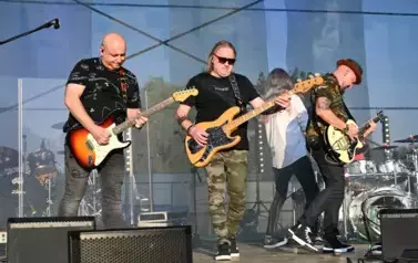 widzimy trzech pan&oacute;w grających na gitarze