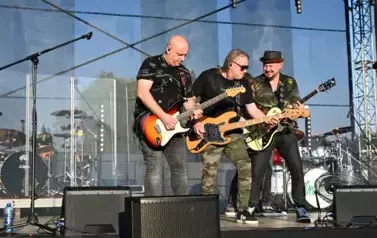 widzimy trzech pan&oacute;w grających na gitarze