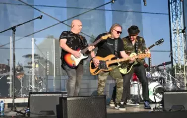 widzimy trzech pan&oacute;w grających na gitarze