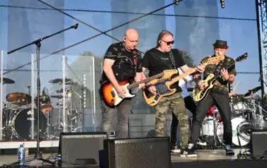 widzimy trzech pan&oacute;w grających na gitarze