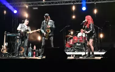 widzimy panią śpiewającą oraz trzech pan&oacute;w grających na instrumentach