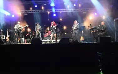 widzimy panią śpiewającą oraz czterech pan&oacute;w grających na instrumentach