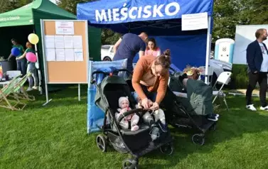 widzimy panią i pana wraz z czw&oacute;rką dzieci w w&oacute;zku przed stoiskiem