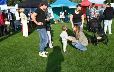 widzimy dwie panie, pana oraz panią kucającą do małego dziecka
