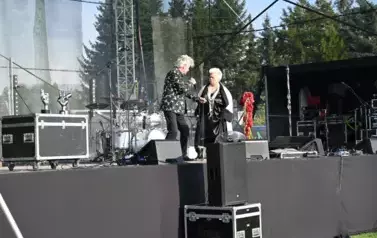 widzimy pana śpiewającego do mikrofonu oraz patrzącego na panią stojącą obok