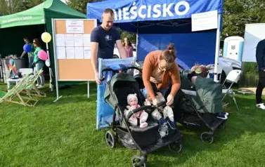 widzimy pana i panią z czw&oacute;rką dzieci w w&oacute;zku oraz zakupionym przedmiotem