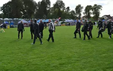 widzimy grupę pan&oacute;w ubranych na motor oraz niekt&oacute;rzy z nich trzymają kaski w dłoniach