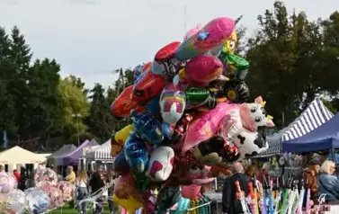 widzimy stoiska z zabawkami oraz balonami z helem 