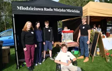 widzimy stoisko Młodzieżowej Rady Miejskiej Mieścisko oraz kilka os&oacute;b stojących przy stoisku