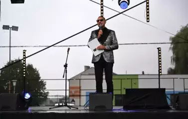 widzimy pana stojącego z mikrofonem w ręce 