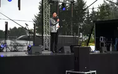 widzimy pana stojącego z mikrofonem w ręce 