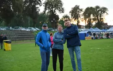widzimy panią oraz dw&oacute;ch pana na tle zieleni 