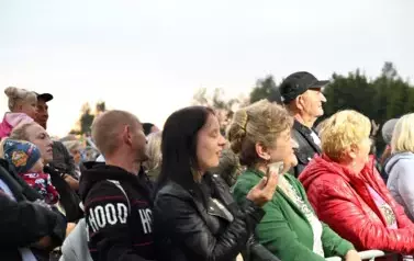 widzimy dużą grupę os&oacute;b słuchającą koncertu