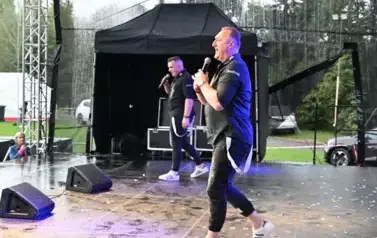 widzimy dw&oacute;ch pan&oacute;w śpiewających na scenie