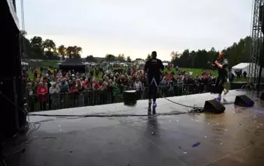 widzimy dużą grupę os&oacute;b słuchającą koncertu