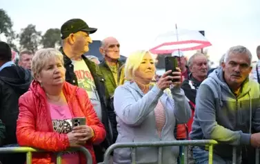 widzimy dużą grupę os&oacute;b słuchającą koncertu