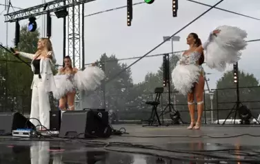 widzimy panią, kt&oacute;ra śpiewa oraz dwie panie tańczące obok niej