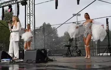 widzimy panią, kt&oacute;ra śpiewa oraz dwie panie tańczące obok niej
