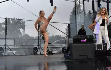 widzimy panią, kt&oacute;ra śpiewa oraz dwie panie tańczące obok niej