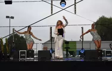 widzimy panią, kt&oacute;ra śpiewa oraz dwie panie tańczące obok niej
