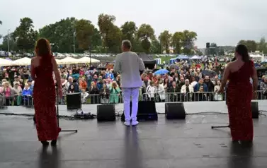 widzimy pana oraz dwie panie śpiewające na scenie