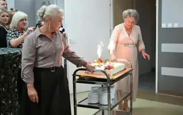 widzimy dwie panie z tortem oraz zapalonymi racami 