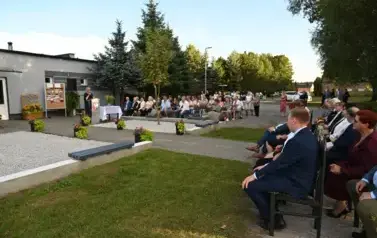widzimy dużą ilość os&oacute;b siedzącą na krzesłach