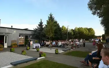 widzimy dużą ilość os&oacute;b siedzącą na krzesłach