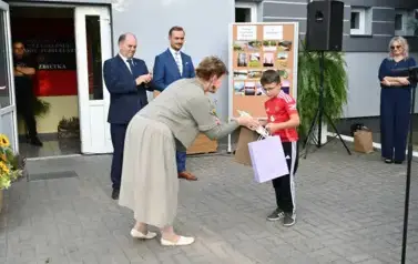 pani przekazuje upominek chłopcu