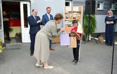 pani przekazuje upominek chłopcu