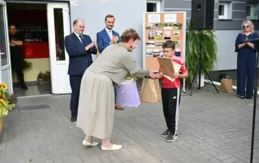 pani przekazuje upominek chłopcu