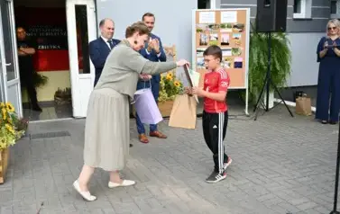 pani przekazuje upominek chłopcu
