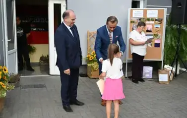 widzimy pana przekazującego upominek dziewczynce 