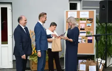 widzimy pana przekazującego upominek w ręce z jednej pań