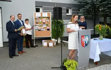 widzimy panią m&oacute;wiącą do mikrofonu oraz 2 panie i 2 pan&oacute;w widocznych w tle