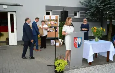 widzimy panią m&oacute;wiącą do mikrofonu oraz 2 panie i 2 pan&oacute;w widocznych w tle