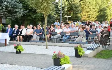 widzimy liczną grupę os&oacute;b siedzącą na krzesłach