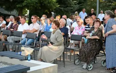 widzimy liczną grupę os&oacute;b siedzącą na krzesłach 