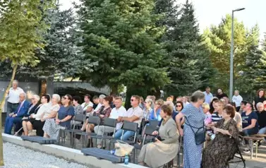 widzimy liczną grupę os&oacute;b siedzącą na krzesłach 