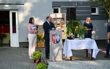 widzimy pana m&oacute;wiącego do mikrofonu oraz dwie panie stojące za nim
