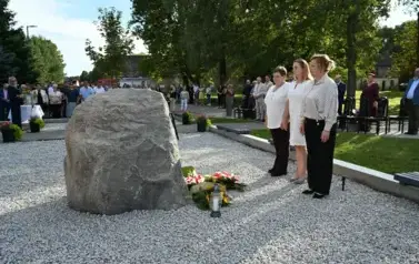 widzimy trzy panie stojące na baczność przed pomnikiem