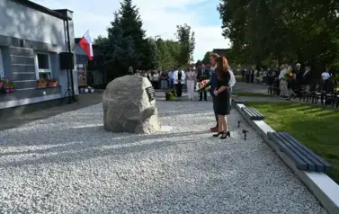 widzimy stojącą przed pomnikiem delegacje z kwiatami