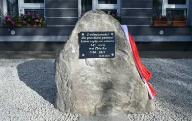 widzimy pomnik z zaczepioną polską flagą