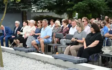 widzimy liczną grupę os&oacute;b siedzącą na krzesłach